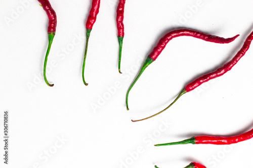 red hot chili peppers, popular spices concept - decorative pattern of red hot chili with green tails on white background, beautiful red collage of freely lying peppers, top view, flat lay