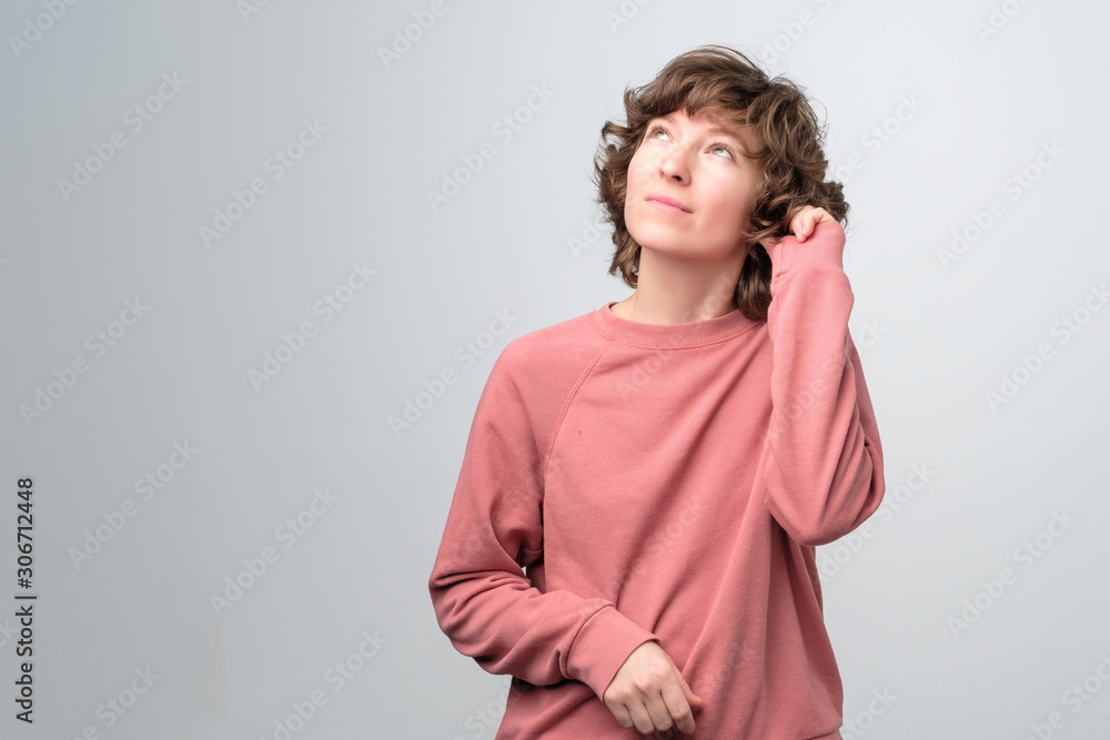 Caucasian mature curly woman in pink pulover dreaming making plans looking up. Caucasian mature curly woman in pink pulover dreaming making plans looking up.