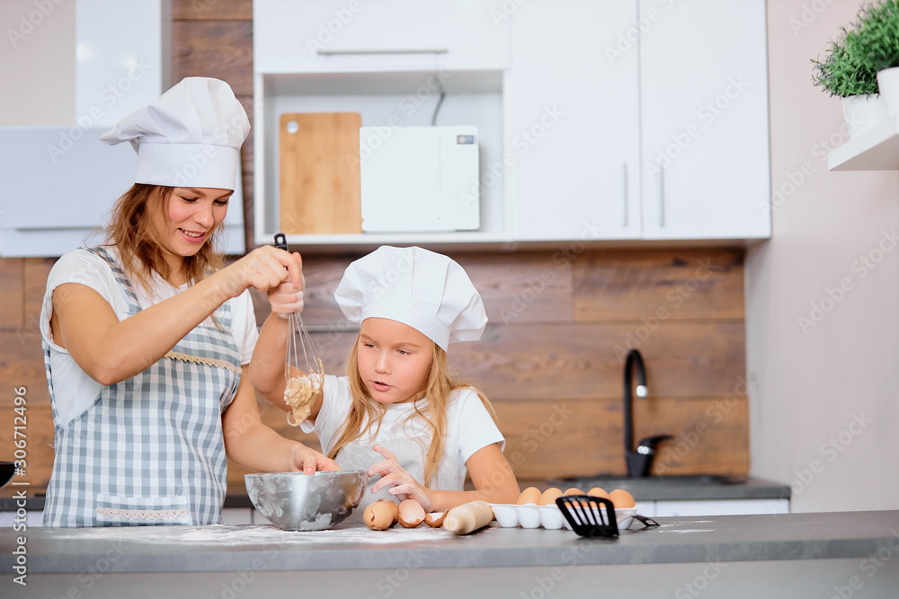 caucasian child making dough with the use of mixer with mother in kitchen at home, use chicken eggs and flour . Prepare ingredients for baking caucasian child making dough with the use of mixer with mother in kitchen at home, use chicken eggs and flour . Prepare ingredients for baking