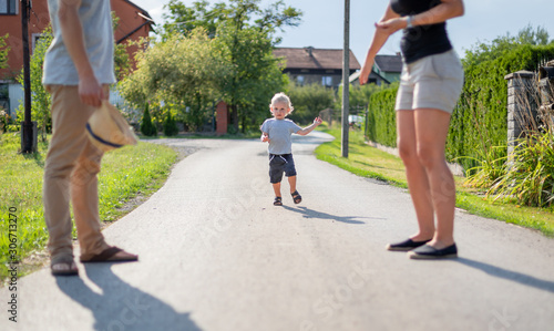 Fototapeta Naklejka Na Ścianę i Meble -  Happy family spending time together walking outdoor at sunny summer day