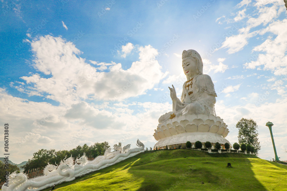 The goddess of compassion and mercy Statue on green grass with blue sky at Chaing rai, Thailand, Buddhist religion concept. The goddess of compassion and mercy Statue on green grass with blue sky at Chaing rai, Thailand, Buddhist religion concept.