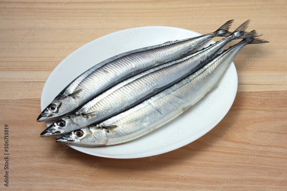 Pacific saury isolated on the wood background Pacific saury isolated on the wood background