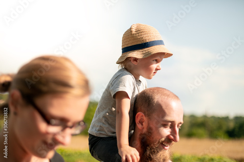 Happy family walking together with child on piggyback © leszekglasner