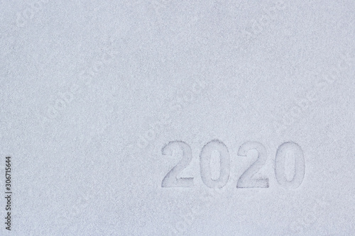 the text of the numbers two thousand twenty in the snow, as a symbol of the coming new year.