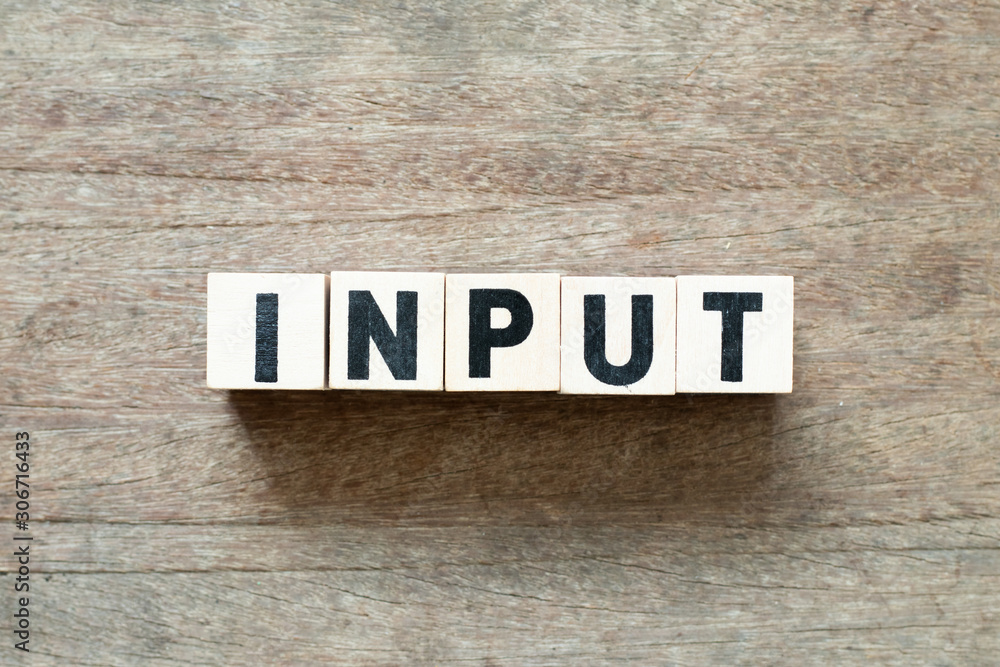Naklejka premium Letter block in word input on wood background