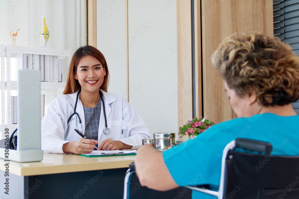 Fototapeta premium Portrait of a beautiful Asian woman doctor smiling and interviewing the patient's symptoms.