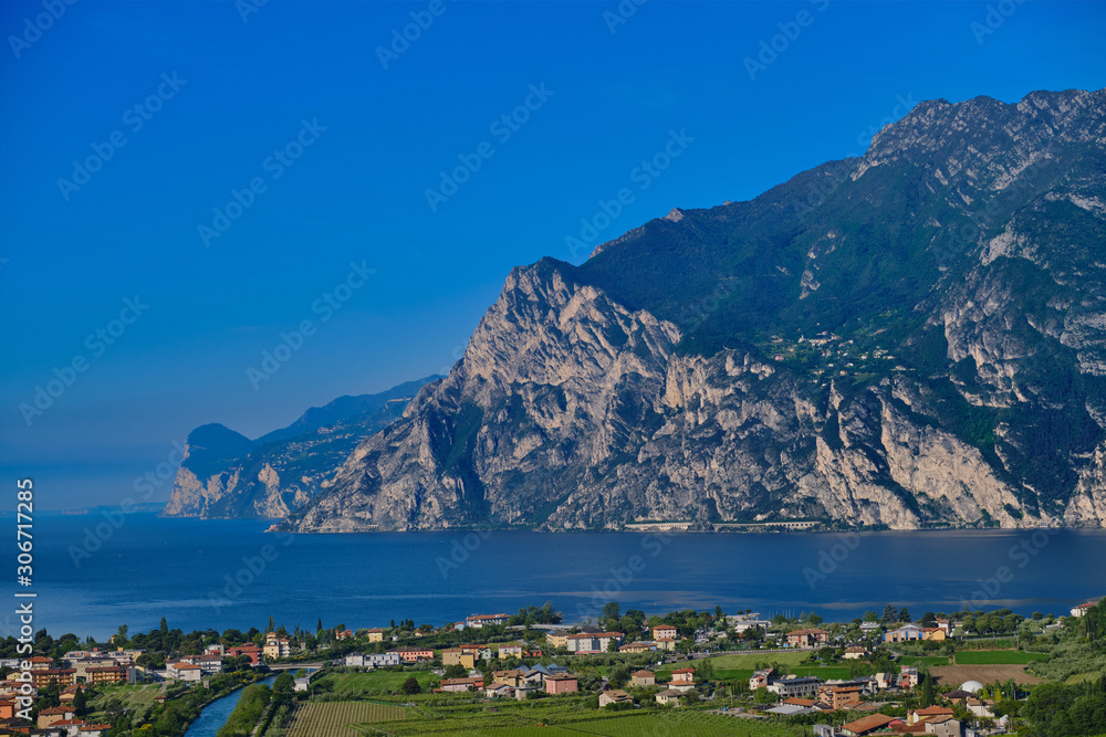 Obraz premium Panorama of Lake Garda surrounded by mountains in Riva del Garda, Italy. Linfano, Italy