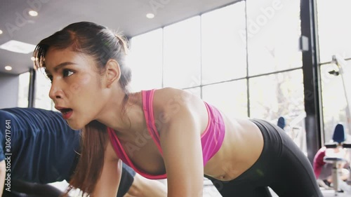 4K UHD Slow motion : Asian sporty woman and team in sportwear is doing mountain climber exercise on the floor at indoor gym.Exercising, Cardio traning and Healthy lifestyle concept. photo