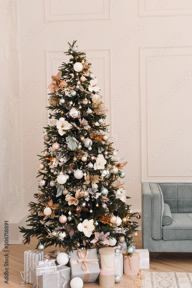 Beige and blue room with Christmas and New Year decorated interior. Christmas tree with gifts in a light interior of the house