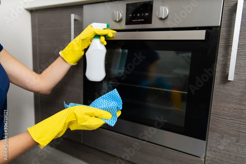 Hand in rubber glove cleans a new kitchen. Woman with housework, cleaning the kitchen.