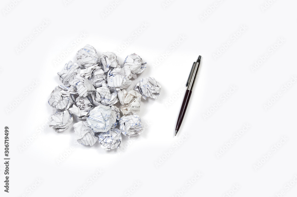 scribbled and crumpled office paper in a pile to the right of the pile a brown pen on a white background scribbled and crumpled office paper in a pile to the right of the pile a brown pen on a white background