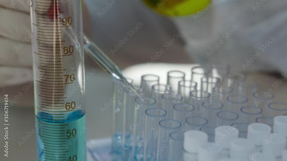 Scientist dripping liquid into test tube. Close up. Scientist dripping liquid into test tube. Close up.