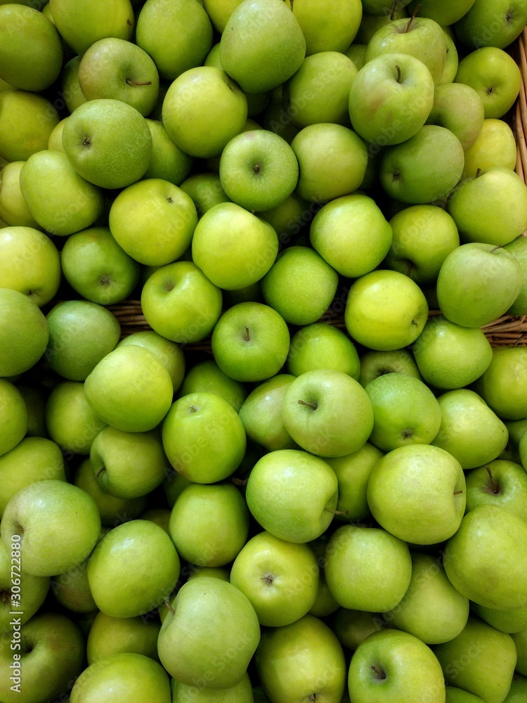 Many green apples in basket at market