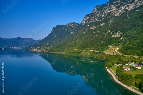 Panoramic view of the mountains and Lake Idro-Lago d Idro. Autumn season  the reflection in the water of the mountains  trees  blue sky