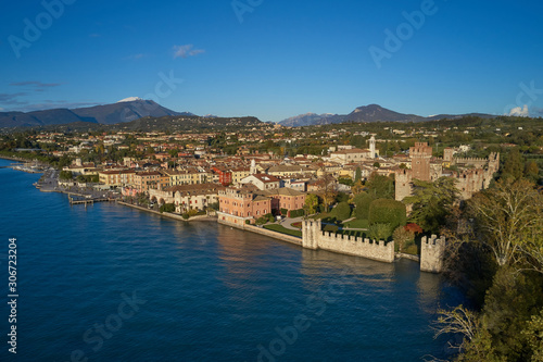 Aerial view of Lake Garda and the city center of Lazise  Italy. Autumn season  blue sky  Alps on the horizon  snow in the mountains