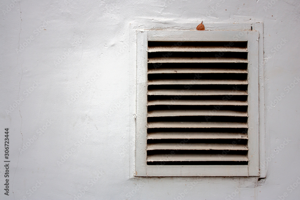 Ventilation grill on a white wall.