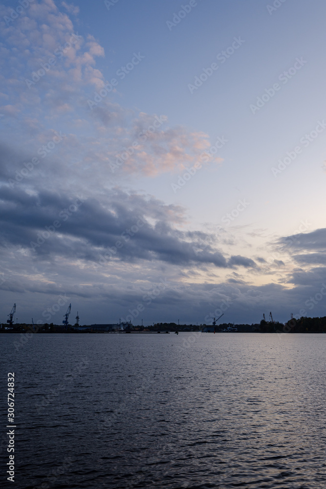 night clouds and lights above industrial port of city Riga in Latvia