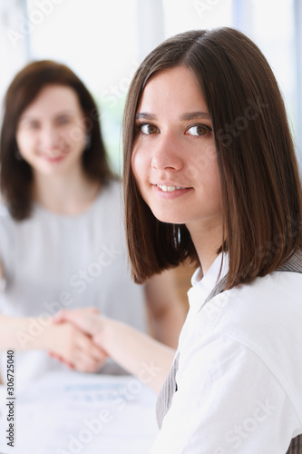 Business woman and woman shake hands as