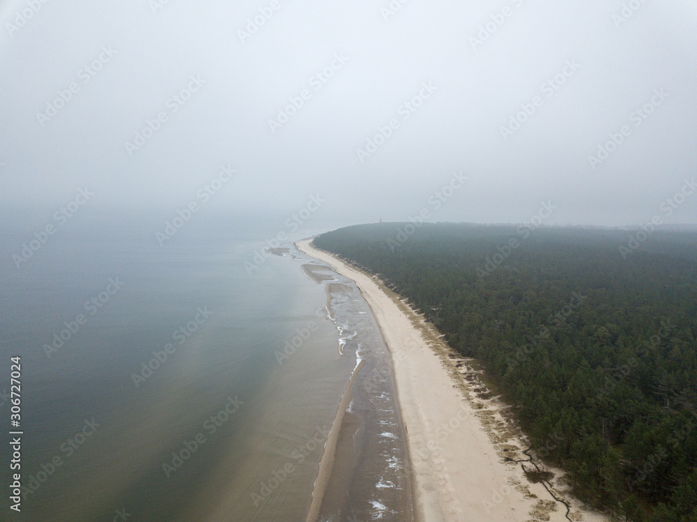 seaside beach with water covered in fog mist seaside beach with water covered in fog mist