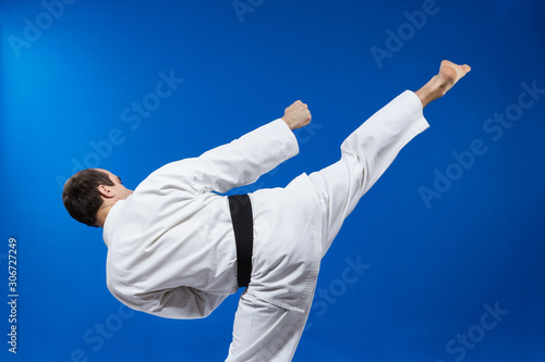 The blow roundhouse beats athlete in karategi