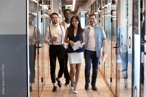 Successful multiethnic employees of company walk in modern office hallway © fizkes