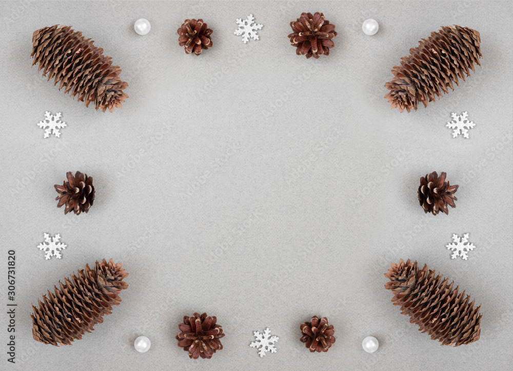Christmas border with silver snowflakes and fir cones on a gray background. Happy New Year. Winter concept. Space for text. Christmas border with silver snowflakes and fir cones on a gray background. Happy New Year. Winter concept. Space for text.