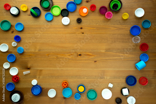  Plastic bottle caps on wooden background. The cover material is recyclable. the concept of environmental protection and ecology