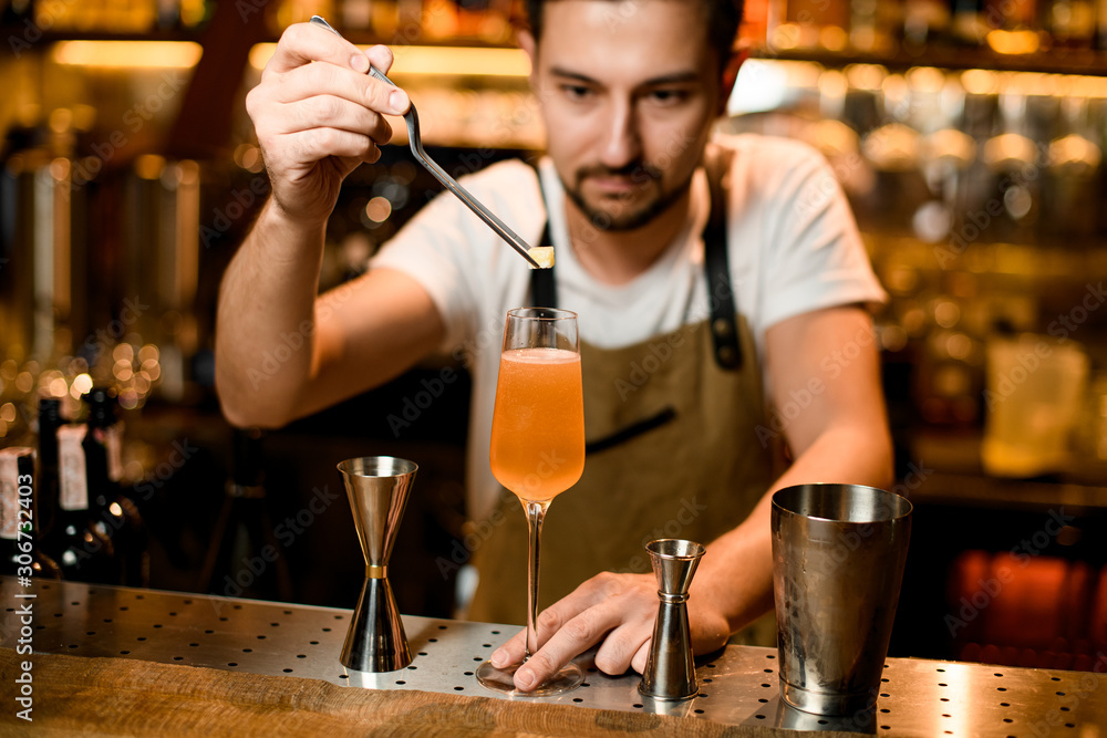 Bartender puts piece of brown sugar in cocktail