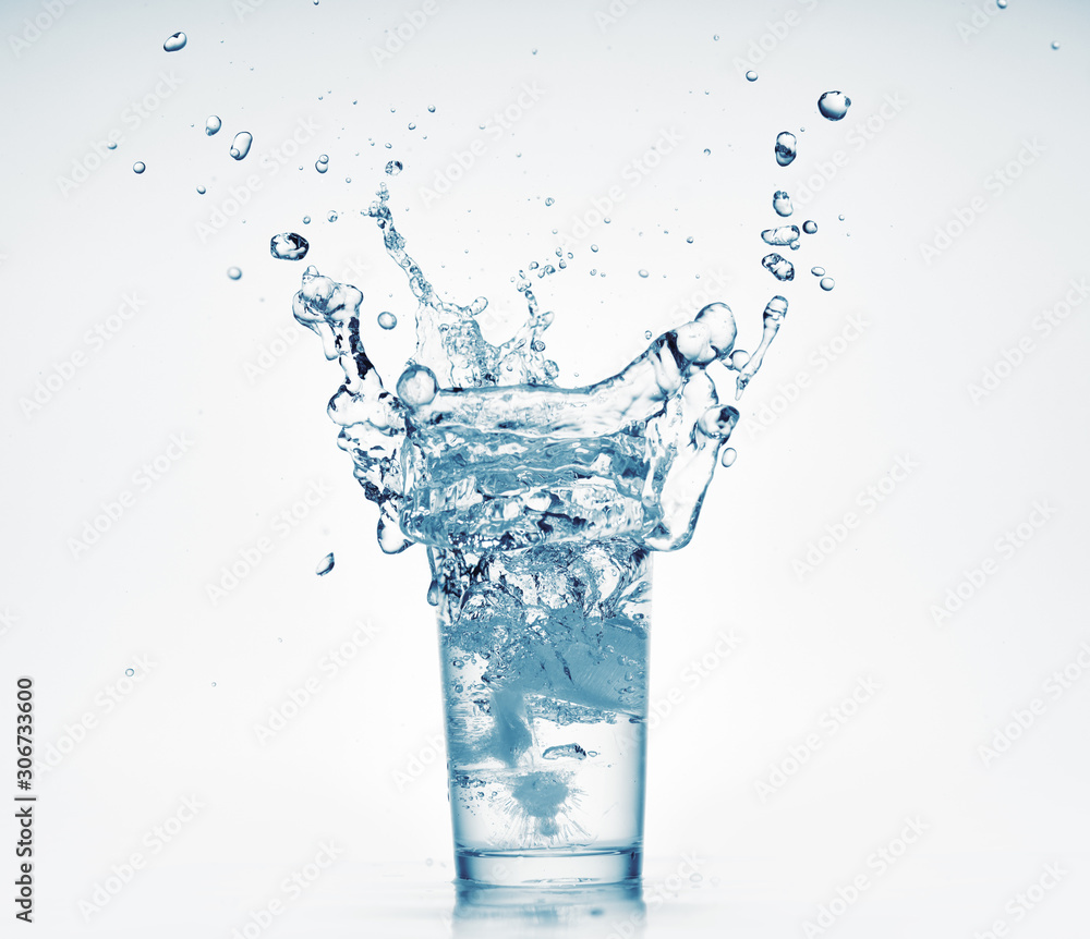 one glass of water with splash from falling ice cube, white background, isolated object one glass of water with splash from falling ice cube, white background, isolated object