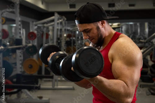  Young man exercising with dumbbells.