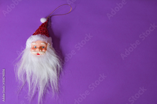 Santa’s head positioned on the left of a violet background