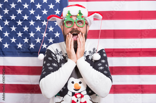 Christmas in USA. Winter holidays season. Turnkey custom holiday design. American guy joined cheerful celebration. American tradition. Santa Claus on american flag. Celebrate xmas and new year © be free