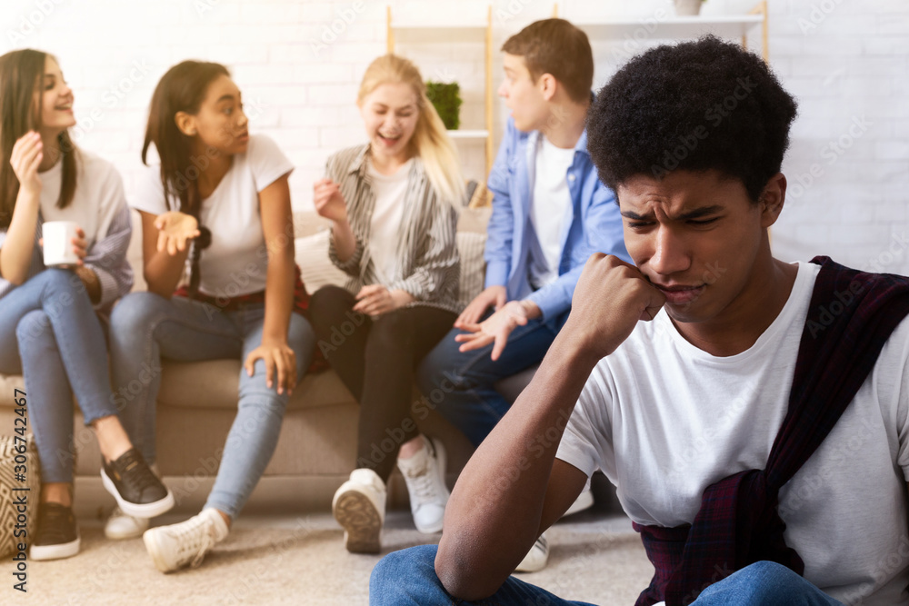 Fototapeta premium Bullying concept. Sad guy avoiding bad friends