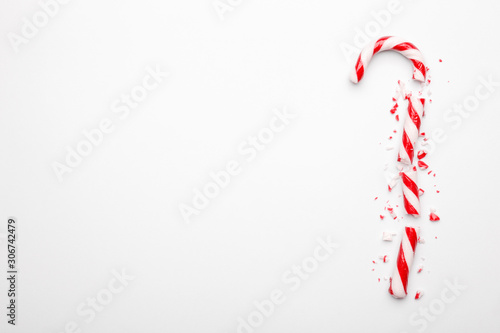 Broken Christmas candy cane on white background. Minimal composition with peppermint candy. Top view © Random435