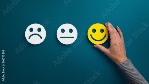 Woman choosing happy smiley face emotion on green photo