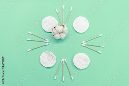 Frame with cotton buds and pads on a mint background. Eco-friendly