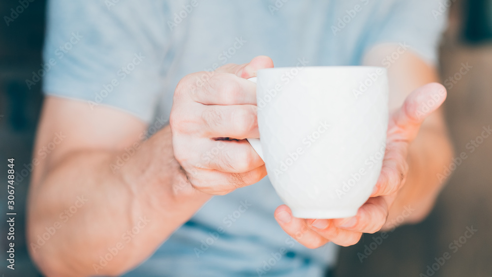 Home hospitality. Hot drink. Man offering tea in white mug. Home hospitality. Hot drink. Man offering tea in white mug.