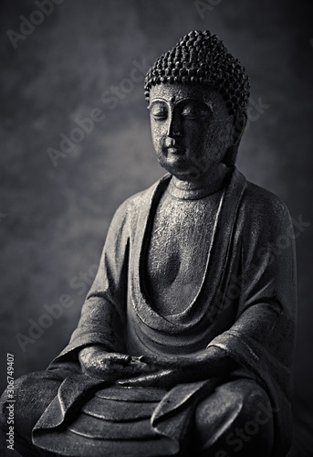 фотографія Meditating Buddha Statue on dark background. Copy space.