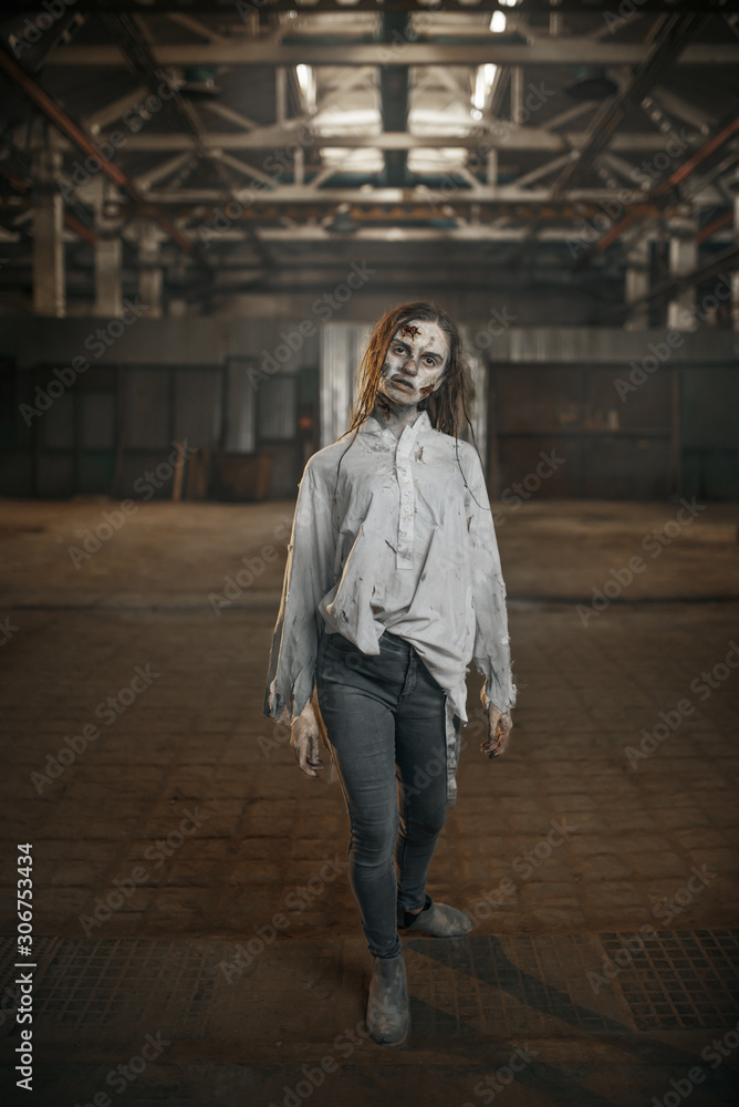 Female zombie walking in abandoned factory, horror