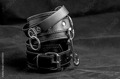 Pair of a black color fetish leather handcuffs.