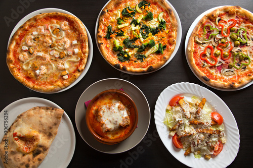 Pizzas and typical Italian dishes seen from above.