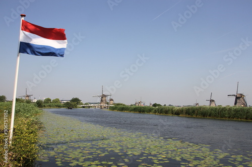 Dutch Flag flying in front of some windmills at the Kinderdijk in the Netherlands