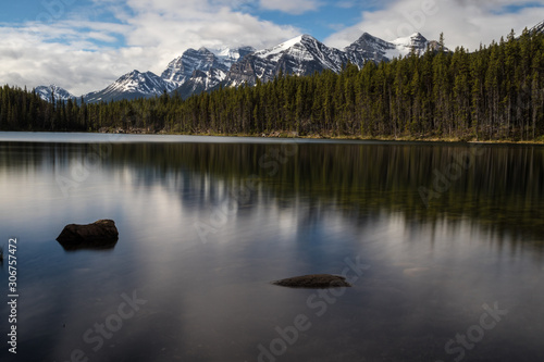 beautiful view of mountains above hector lake in banff national park with calm waters