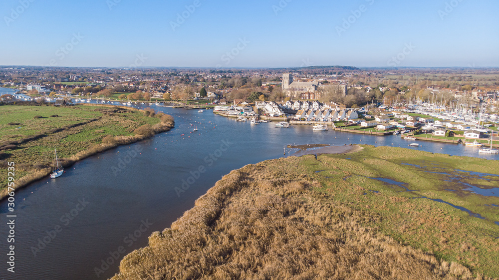 An aerial view of a river with marina, church and city building in the background under a majestic blue sky An aerial view of a river with marina, church and city building in the background under a majestic blue sky