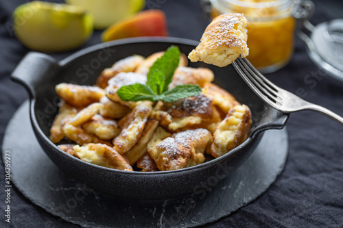 Piece of Kaiserschmarrn on a fork infront of a pan