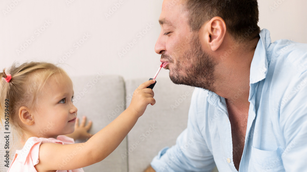 Cute girl applying makeup on her dad Cute girl applying makeup on her dad