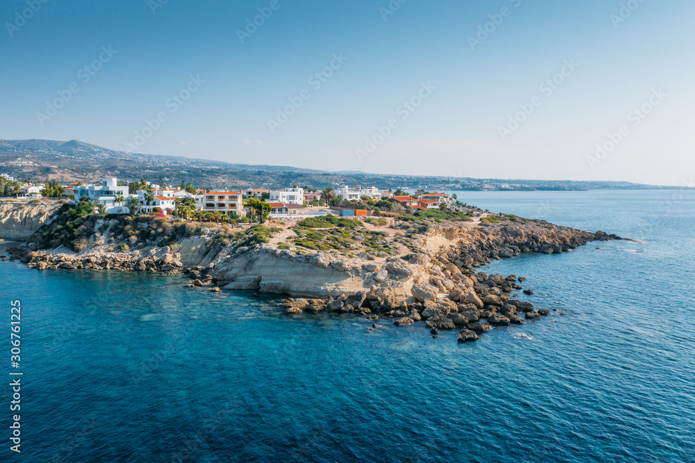 Aerial view of beautiful nature cliff with villas or houses near Coral Bay beach in Paphos, Cyprus. Drone photo of mediterranean seascape background.