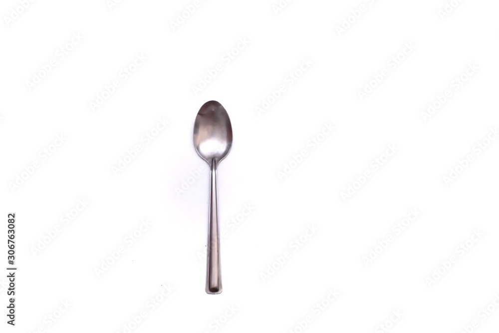 A small stainless glossy spoon on white isolated background with copy space A small stainless glossy spoon on white isolated background with copy space