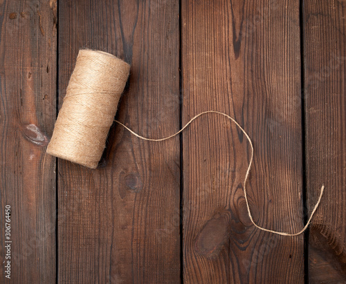 brown thread twisted into a spool on a wooden background