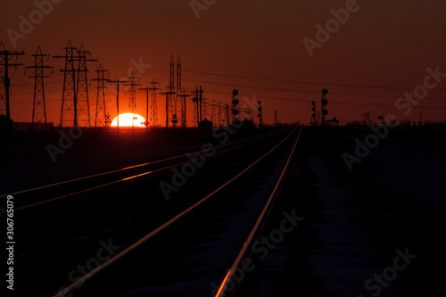 Sunset Silhouette of Transmission Towers and Railway Tracks